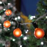 25 G40 Globe String Light Set with Orange Satin Bulbs on Black Wire